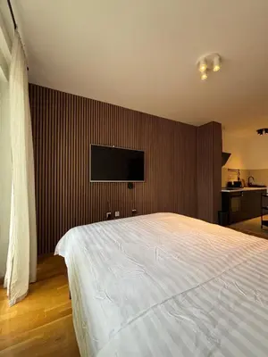 a bedroom with a large bed and a flat screen tv at Apartman MINI in Doboj