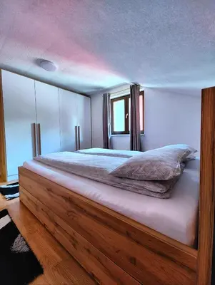 a bedroom with a large bed with a wooden frame at Apartment Residence House in Bihać