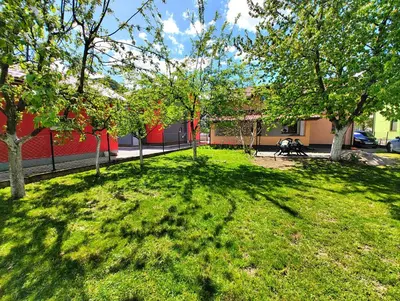a grassy yard with trees and a building at Apartment Residence House in Bihać