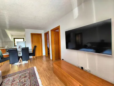 a living room with a large flat screen tv on a wall at Apartment Residence House in Bihać