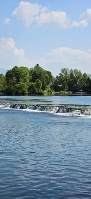 a river with a waterfall and trees in the background at Apartment Residence House in Bihać