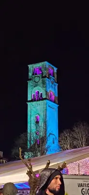 a blue clock tower with purple lights on it at Apartment Residence House in Bihać