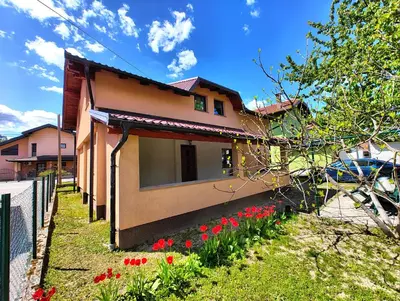 a house with red flowers in the yard at Apartment Residence House in Bihać