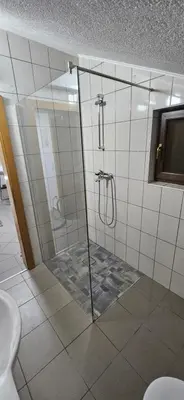 a shower with a glass door in a bathroom at Apartment Residence House in Bihać