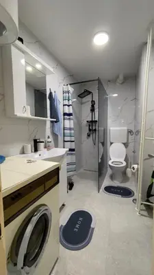 a bathroom with a washing machine and a toilet at HomeSpot Banja Luka in Banja Luka