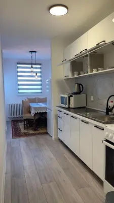 a kitchen with white cabinets and a dining room with a table at HomeSpot Banja Luka in Banja Luka