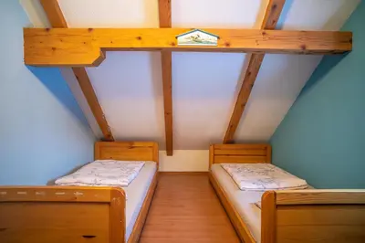 two bunk beds in a small room with wooden ceilings at Planinska Kuća OBLAK in Kupres
