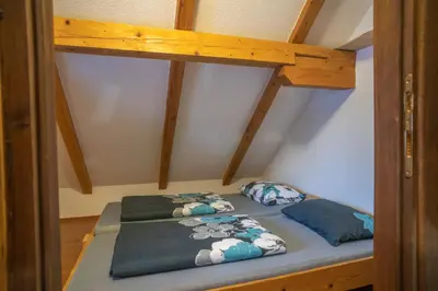 a bunk bed with two pillows on it in a room at Planinska Kuća OBLAK in Kupres