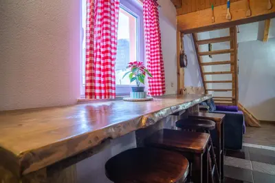 a dining room with a wooden table and chairs at Planinska Kuća OBLAK in Kupres