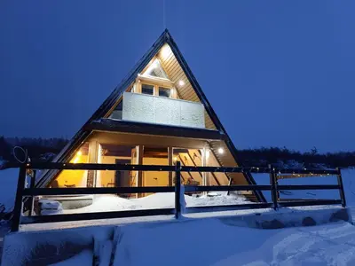 a cabin in the snow with a lit up window at Mountain house Tomislavgrad in Tomislavgrad