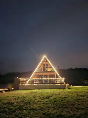 a house with lights on the side of it at night at Mountain house Tomislavgrad in Tomislavgrad