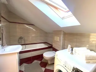 a bathroom with a sink toilet and a skylight at Apartman Panorama in Tomislavgrad