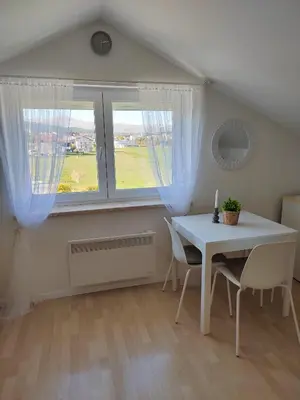 a dining room with a white table and a window at Apartman Panorama in Tomislavgrad