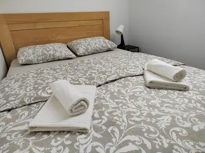 a bed with two pillows and towels on it at Apartman Panorama in Tomislavgrad
