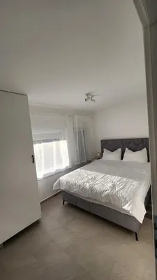 a bedroom with a large bed and a window at Apartman Milica in Banja Luka