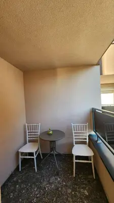 two chairs and a table in a room with a table at Apartman Milica in Banja Luka