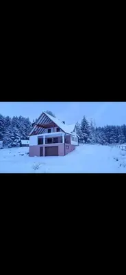 a house is covered in snow in a field at Vikendica Bilanović in Donji Vakuf