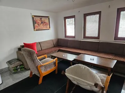 a living room with a couch and a table and chairs at Vikendica Bilanović in Donji Vakuf
