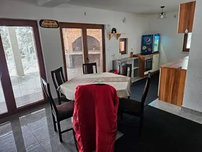 a kitchen with a table with a red blanket on it at Vikendica Bilanović in Donji Vakuf