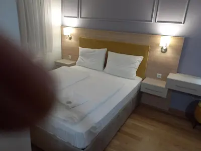 a bedroom with a bed with white sheets and pillows at MN apartman in Banja Luka