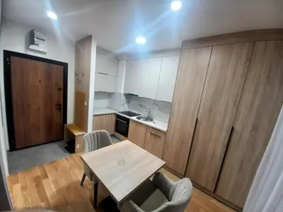 a small kitchen with a table and chairs in a room at MN apartman in Banja Luka