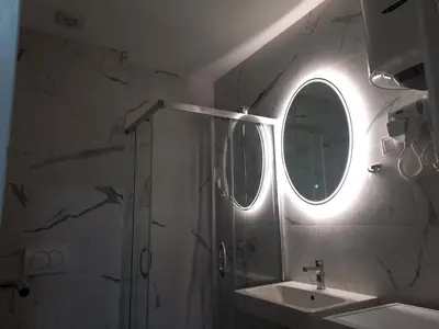 a bathroom with a shower and a sink and a mirror at MN apartman in Banja Luka