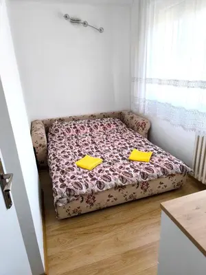 a bed sitting in a room with yellow folders at Apartment Sneki Banja Luka in Banja Luka
