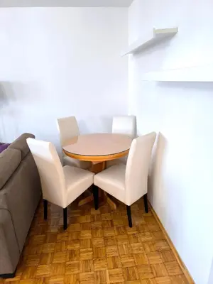 a dining room with a table and two white chairs at Apartment Sneki Banja Luka in Banja Luka
