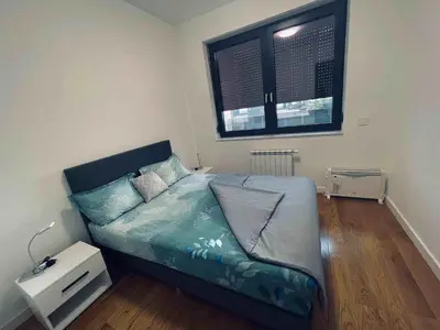 a bed in a room with a window and a bed sidx sidx sidx at Apartman MB in Banja Luka