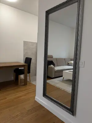 a mirror in a living room with a couch and a table at Apartman MB in Banja Luka
