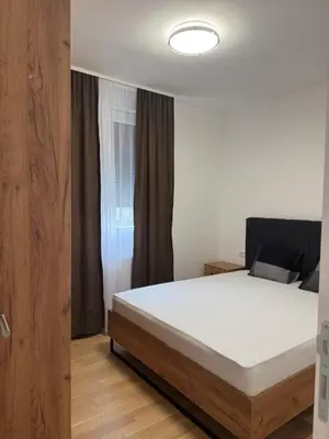 a bedroom with a white bed and a window at Apartman Dublin in Banja Luka