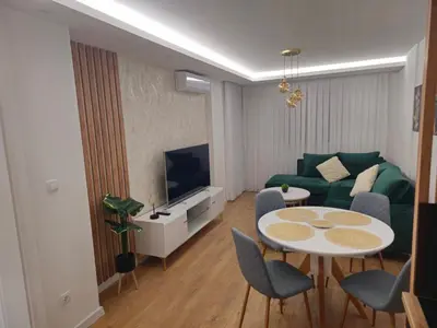 a living room with a green couch and a table at Apartman Dora in Doboj