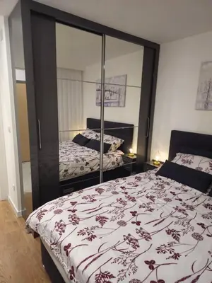 a bedroom with two beds and a large mirror at Apartman Dora in Doboj