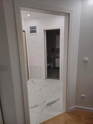 a hallway with a mirror and a room at Apartman Dora in Doboj