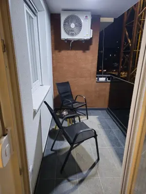 a small room with two chairs and a fan at Apartman Dora in Doboj