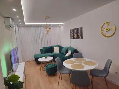 a living room with a green couch and a table at Apartman Dora in Doboj