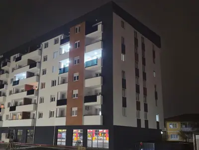 a tall apartment building at night with lights on at Apartman Dora in Doboj