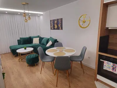 a living room with a couch and a table and chairs at Apartman Dora in Doboj