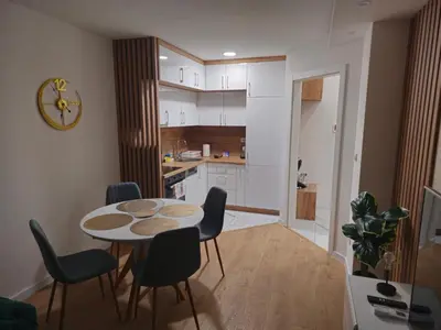 a kitchen with a table and chairs in a room at Apartman Dora in Doboj