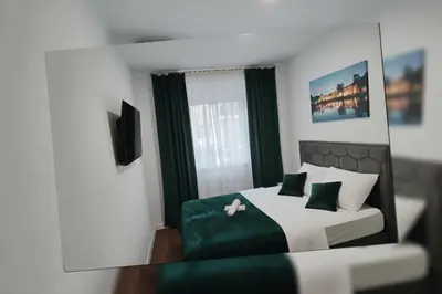 a reflection of a bedroom with a bed and a mirror at Stan Tropico de Lux Banja Luka in Budžak