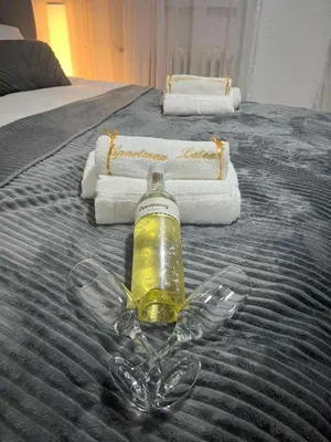 a bottle of alcohol sitting on top of a bed at Apartman Latea in Banja Luka