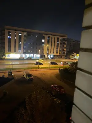 a parking lot with cars parked in front of a building at Apartman Latea in Banja Luka