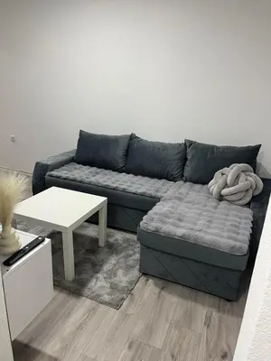 a living room with a blue couch and a table at Apartman Latea in Banja Luka
