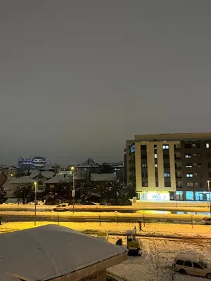 a city with a building and a parking lot with cars at Apartman Latea in Banja Luka