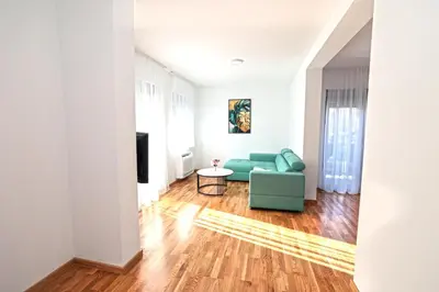 a living room with a green couch and a table at Apartman Dentalux 1 in Banja Luka