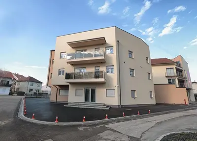 a tall building in a parking lot at Apartman Dentalux 1 in Banja Luka