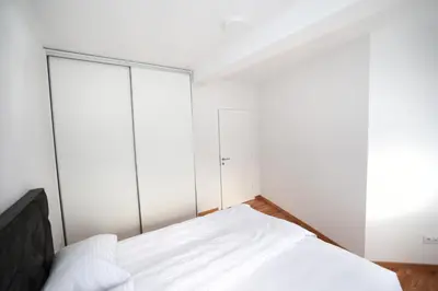a bedroom with white walls and a bed at Apartman Dentalux 4 in Banja Luka