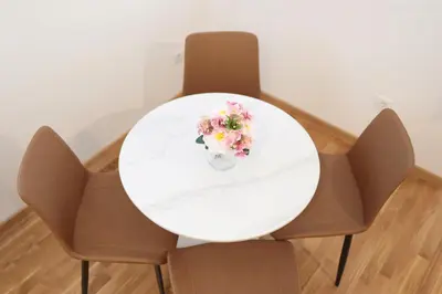 a white table with a vase of flowers on it at Apartman Dentalux 4 in Banja Luka
