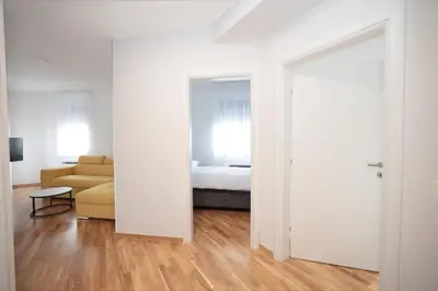 an open door to a bedroom with a bed and a couch at Apartman Dentalux 4 in Banja Luka