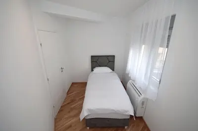 a small white room with a bed and a window at Apartman Dentalux 4 in Banja Luka